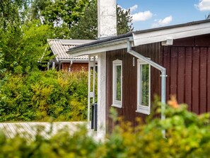 Ein Holzhaus mit weißer Fassade und einer Veranda.