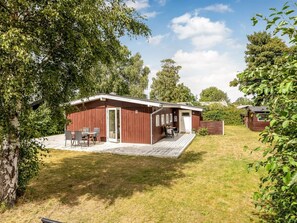 A single-story wooden cabin with a deck, a dining area, and a small kitchen. - "Ulli" - 350m from the sea by Interhome (Grenaa)
