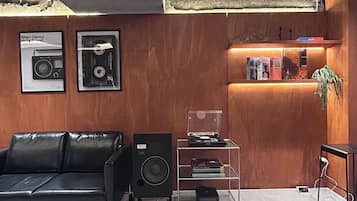 A modern interior with a leather sofa, a black speaker, and a wooden reception desk.