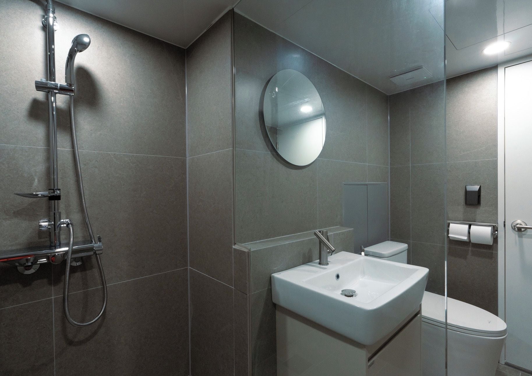 Ein modernes Badezimmer mit Dusche, Waschbecken und Toilette.