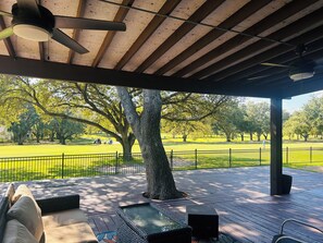 A covered outdoor seating area with a view of a park.
