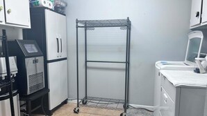 Uma cozinha compacta com geladeira, cafeteira, micro-ondas e uma pia pequena.