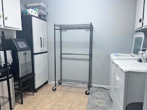 A kitchenette with a refrigerator, a coffee machine, a microwave, and a small sink. - Tranquil 3-bedroom house with AC in charming Bryan (Bryan)