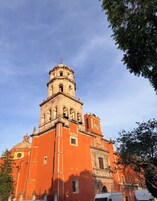 Una iglesia histórica con una destacada torre campanario y una cúpula.