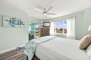 A bedroom with a bed, a ceiling fan, a TV, and a window with curtains. - Little Lagoon Waterfront • Private Pier • West Beach •  Dockside Oasis by Kaiser (Gulf Shores)