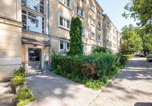 A building with a traditional facade, a small entrance, and a well-maintained hedge. - Nowolipie Cozy Haven Studio (Warszawa)