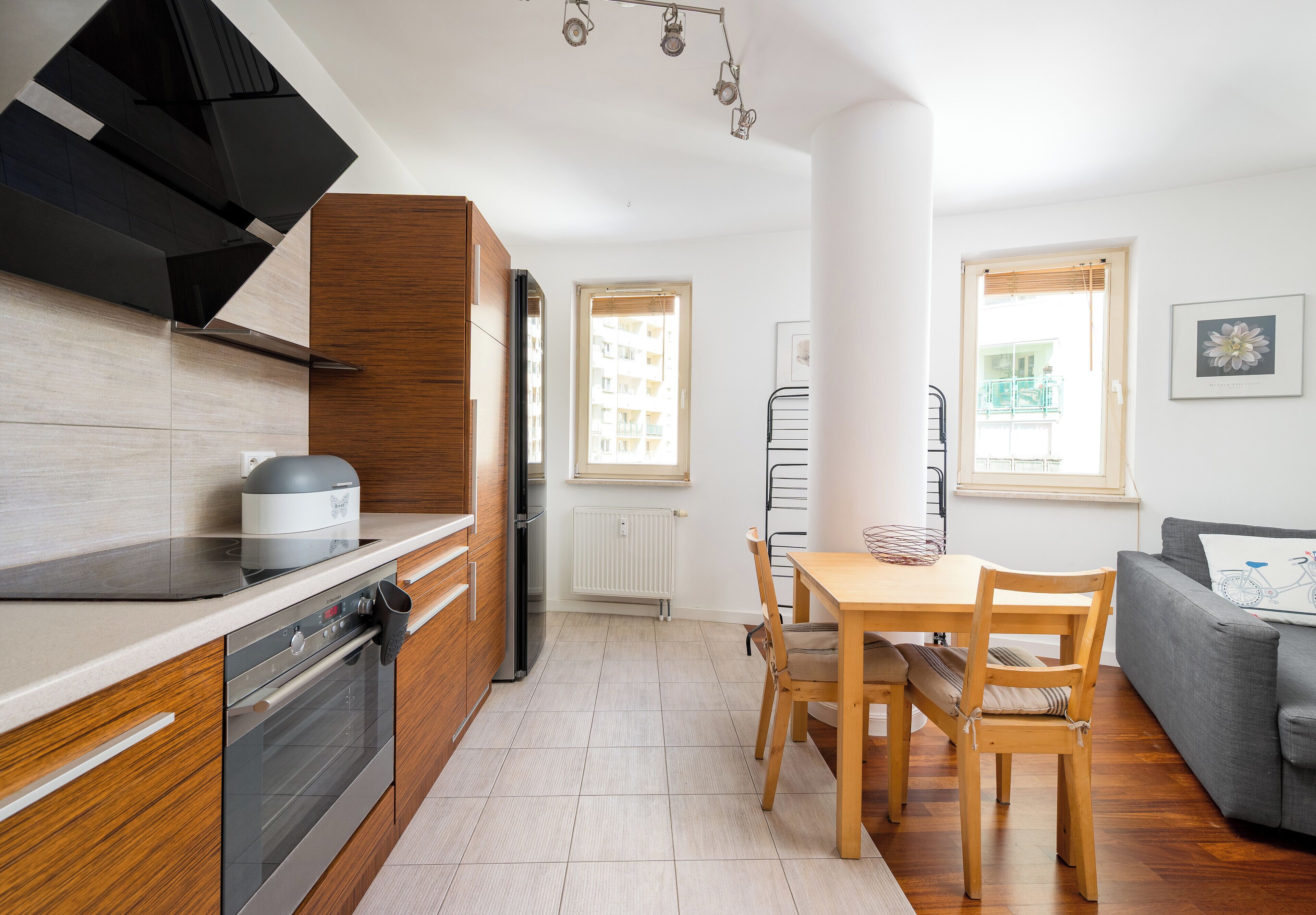 A modern kitchen with a stove, oven, and a dining area with a table and chairs.