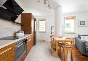 Une cuisine moderne équipée d’une cuisinière, d’un four et d’un coin repas avec une table et des chaises.