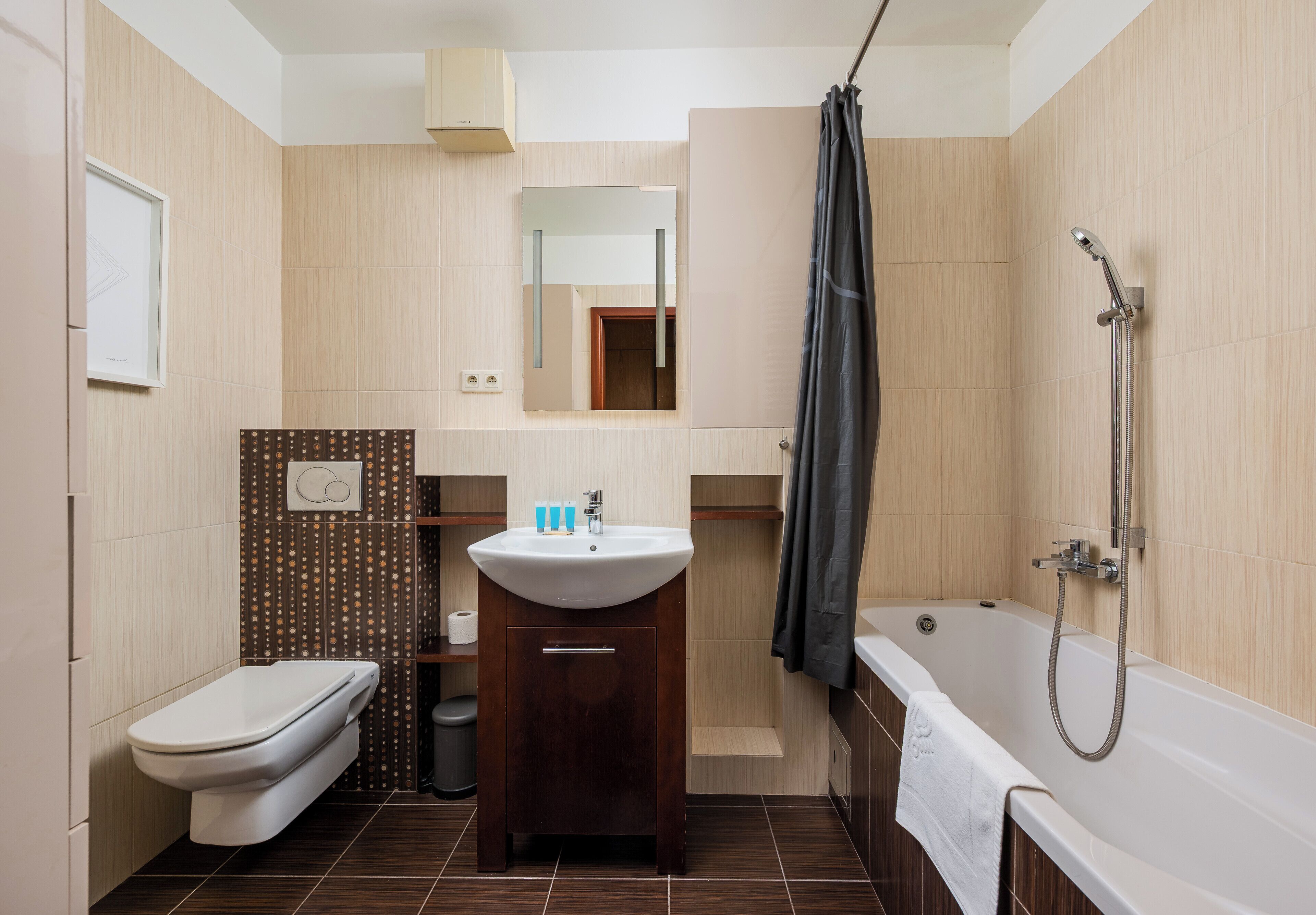 A modern bathroom with a toilet, sink, and bathtub.