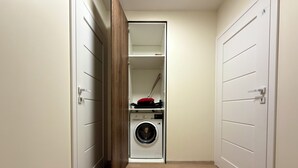 A laundry room with a washing machine and a drying rack. - Madalińskiego Modern Studio 8B (Wrocław)