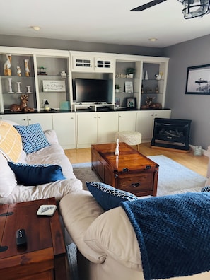 Ein Wohnzimmer mit einer Couch, einem Couchtisch und einem Fernseher auf einem Schrank.