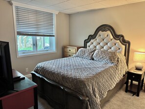 A bedroom with a bed, a nightstand, a dresser, a window, and a television. - 3-bedroom 2,400 sq. ft. Lake House with Amazing Lake Views. (Stewart)