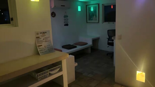 Ein Zimmer mit einem Bett, einem Schreibtisch und einem Stuhl. An den Wänden sind Lampen angebracht und es gibt ein Fenster.