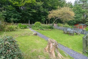 A garden with a gravel path, green grass, and a wooden fence. - Views over Yr Wyddfa (Snowdon)  and the Welsh Highland Railway | Bron-Eifion (Rhyd Ddu)