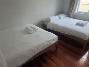A hotel room with two single beds, each with white linens and rolled towels. - 11 Double 4 Sofa Beds 5-bedroom House (Auckland)