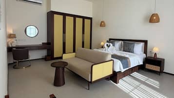 A hotel room with a bed, bedside tables, a desk, a chair, and a wardrobe.
