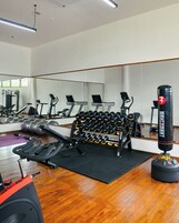 A gym with exercise equipment, a punching bag, and a mirror.