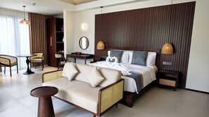 A hotel room with a bed, a sofa, a desk, and a chair.