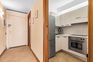 A kitchen with white cabinets, a stainless steel refrigerator, a stove, and a tiled backsplash. - 2 Bedrooms Apartment Sea View & Garage Marina, Villeneuve-Loubet, France (Villeneuve-Loubet)