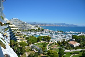 A marina with numerous boats, a large hotel with multiple balconies, and a clear view of the coastline. - 2 Bedrooms Apartment Sea View & Garage Marina, Villeneuve-Loubet, France (Villeneuve-Loubet)