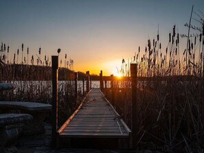 A wooden pier leading to a body of water with tall grasses on either side. - Lake House on Bluff Lake - Nature Lovers Paradise (Lake)