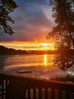 A sunset view over a calm lake with a dock and trees. - Lake House on Bluff Lake - Nature Lovers Paradise (Lake)