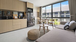 Un apartamento moderno con kitchenette, zona de comedor y sala de estar con ventana grande.