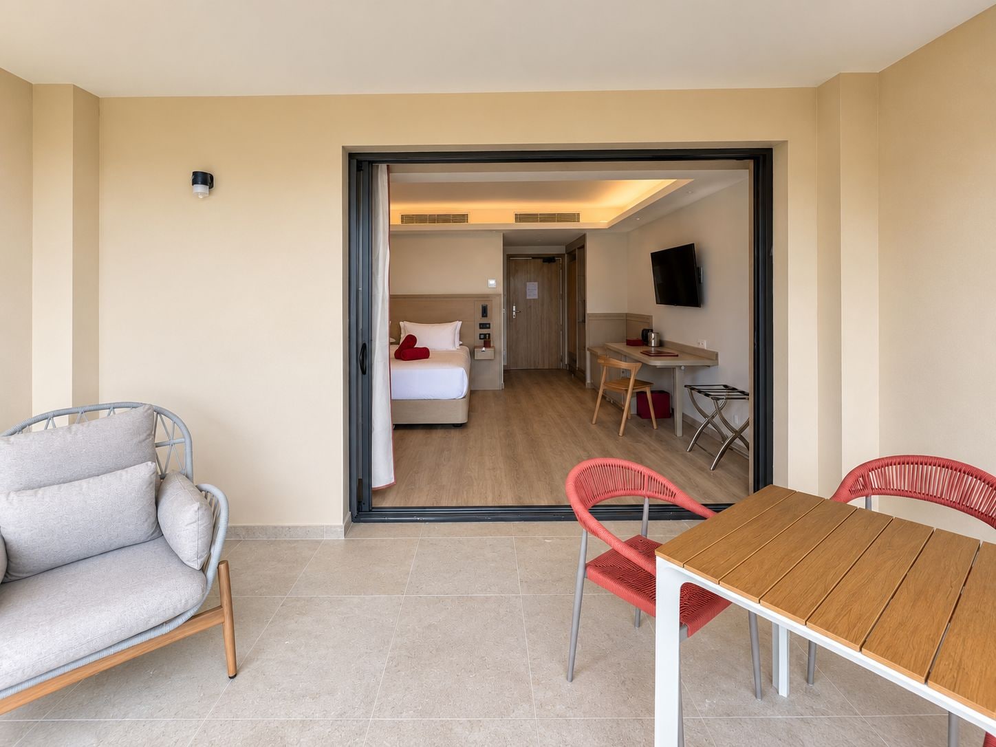 A hotel room with a bed, a desk, a chair, and a television.