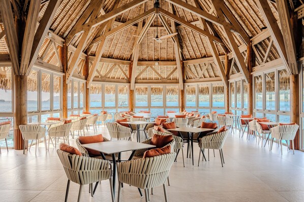 A spacious indoor area with high ceilings, large windows, and a view of the sea. - Bloody Mary's Hotel (Bora Bora)