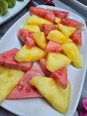 A white plate with triangular pieces of watermelon and cantaloupe. - Bloody Mary's Hotel (Bora Bora)