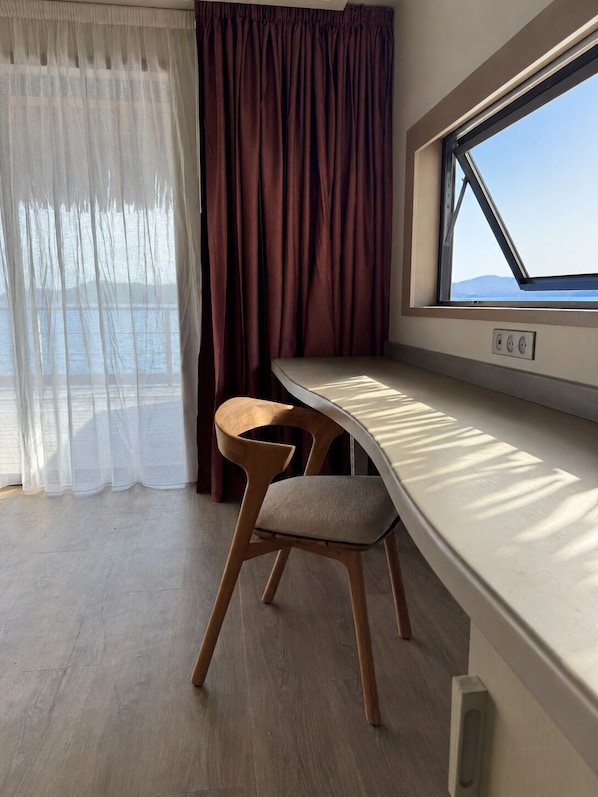 A room with a window, a table, and a chair.