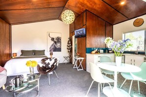 Une chambre d’hôtel moderne équipée d’un lit, d’un canapé, d’une table à manger et d’un coin cuisine.