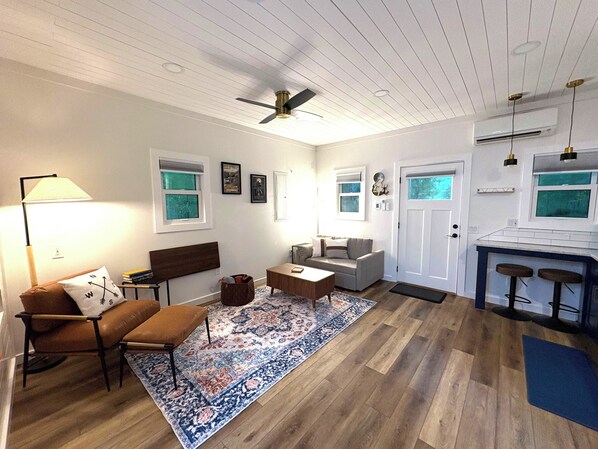A living room with a sofa, a coffee table, a rug, and a lamp.