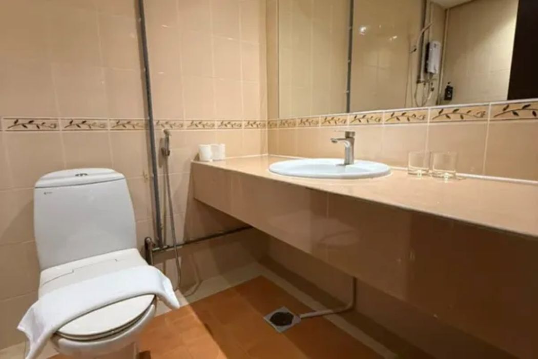 Ein Badezimmer mit Toilette, Waschbecken und Spiegel.