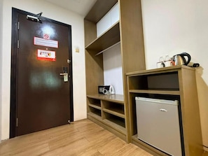 A hotel room with a wooden door, a minibar, and a small refrigerator. - Kingston Hotel 25 @ Summit Signature Batu Pahat, Johor (Batu Pahat)