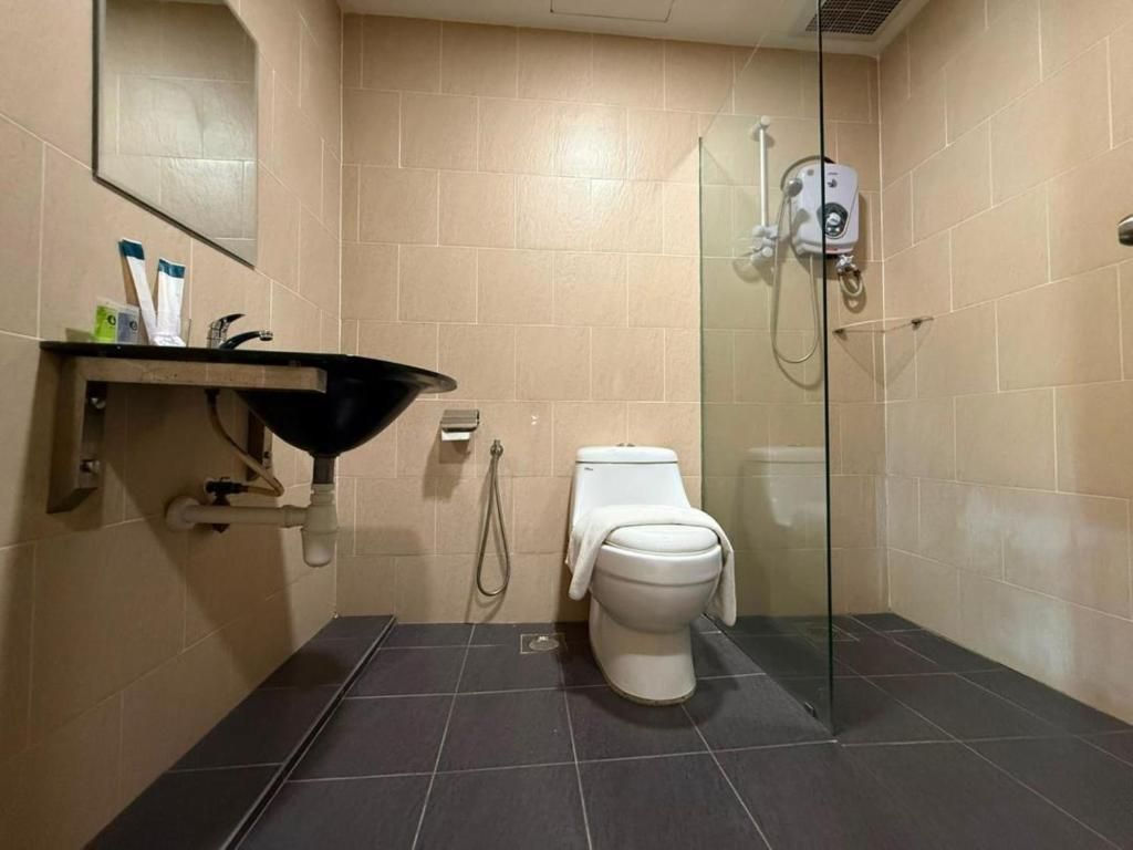 Un baño con inodoro, lavabo y ducha.