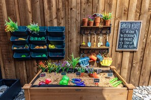 A garden with labeled plants, a chalkboard with garden rules, and gardening tools on hooks. - Ultimate family friendly retreat: pool, spa & epic game-room in Frisco, TX. (Frisco)
