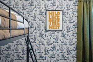 A bunk bed with a framed poster on the wall and a patterned wallpaper. - Ultimate family friendly retreat: pool, spa & epic game-room in Frisco, TX. (Frisco)