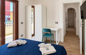 A hotel room with a bed, a desk, a chair, and a wardrobe. - Maison marina Suite - Corfù (Paola)