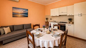 A compact living space with a dining area, kitchenette, and a sofa. - 1 bedroom gorgeous apartment in Saline Joniche (Saline Joniche)