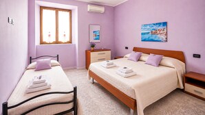 A bedroom with a bed, a bedside table, a dresser, a window, and a painting on the wall. - 1 bedroom gorgeous apartment in Saline Joniche (Saline Joniche)
