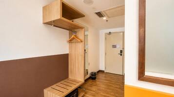A room with a wooden bench, a coat rack, and a door in the background.