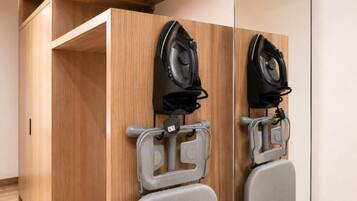 A wooden wardrobe with a mirror and two hair dryers mounted on it.