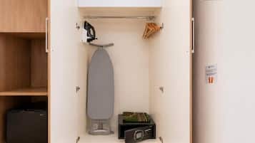 Ein gemütlicher Raum mit integriertem Bügelbrett, einem kleinen Schrank und einem Schuhregal.