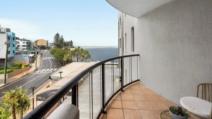 Ein Balkon mit Blick auf die Straße und das Meer.
