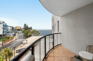Ein Balkon mit Blick auf die Straße und das Meer.