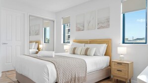 Ein Schlafzimmer mit einem Bett, Nachttischen und Bildern an den Wänden.