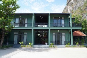 A two-story building with a balcony on the upper level, a covered entrance, and a small annex with a red roof. - Laman Riverside (Hoa Lu)
