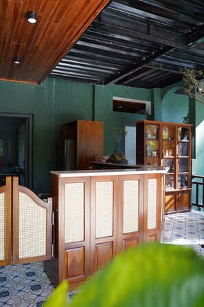 A kitchen with a wooden counter, a refrigerator, and a cabinet with glass doors. - Laman Riverside (Hoa Lu)