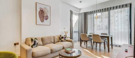 Una sala moderna con un sofá, una mesa de centro y un comedor con sillas y una mesa.